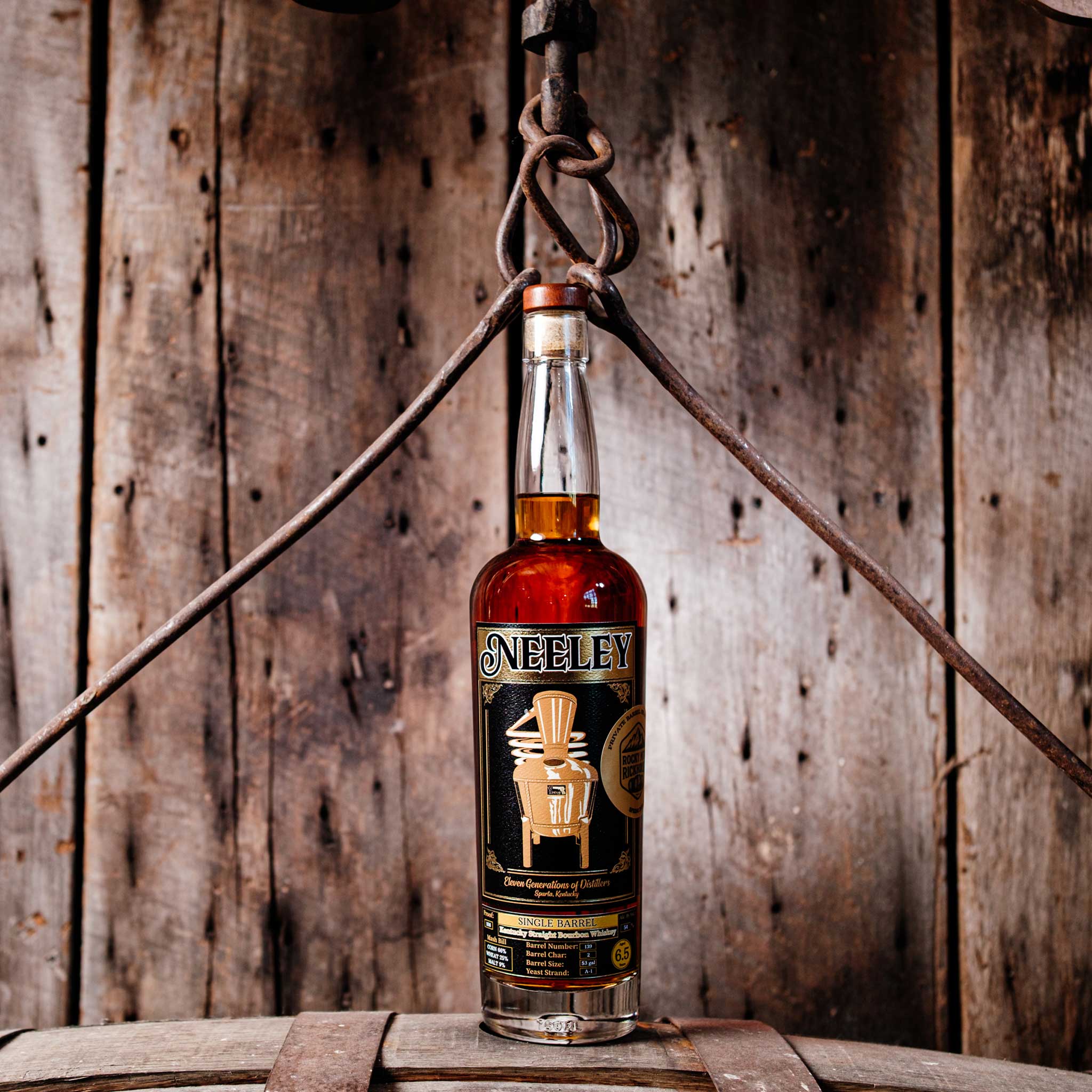 Bottle of Neeley Family Distillery Bottled-In-Bond Whiskey over a barrel