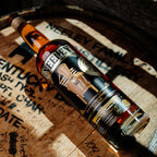 Bottle of Neeley Family Distillery Bottled-In-Bond Whiskey over a barrel