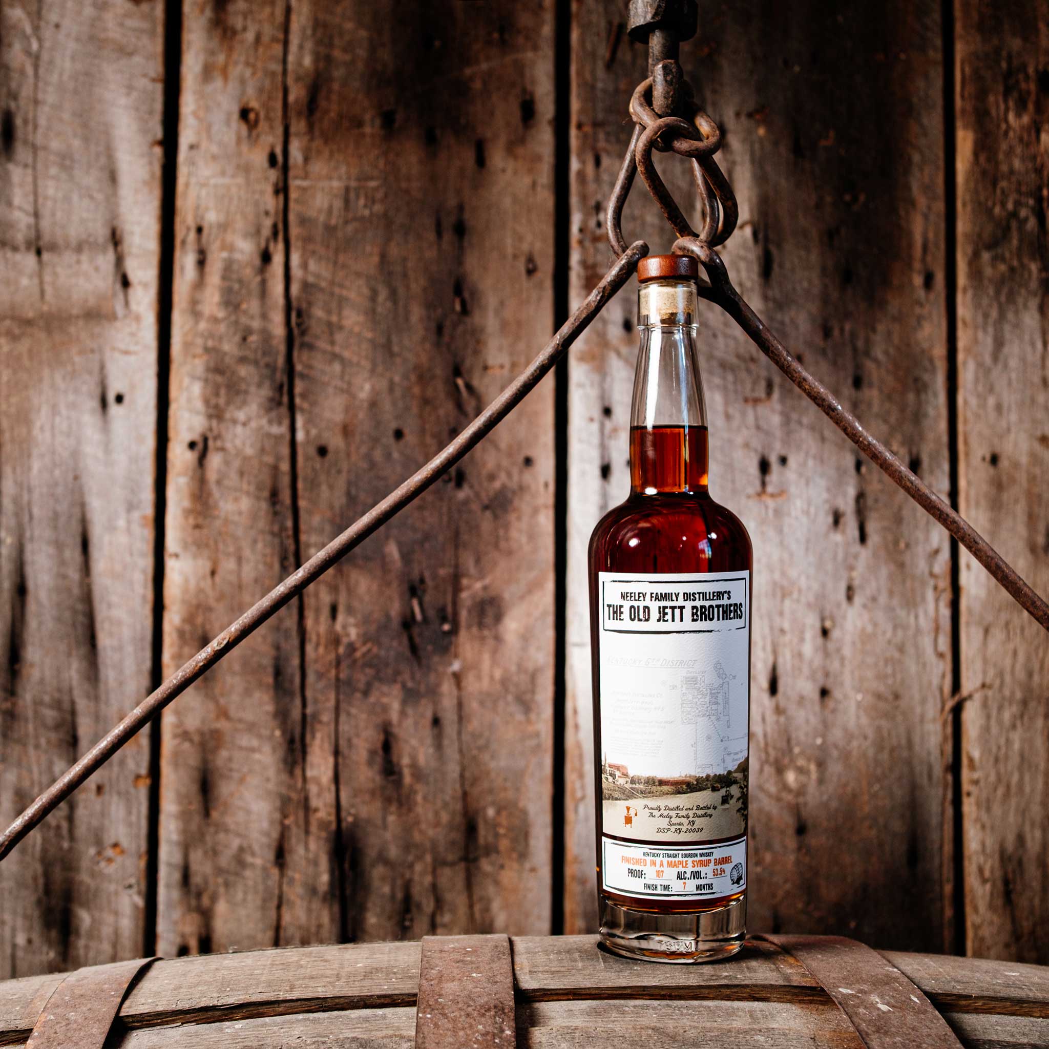 Bottle of Neeley Family Distillery Old Jett Brothers Whiskey over a barrel