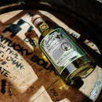 Bottle of Neeley Family Distillery Absinthe Verte on a wooden barrel