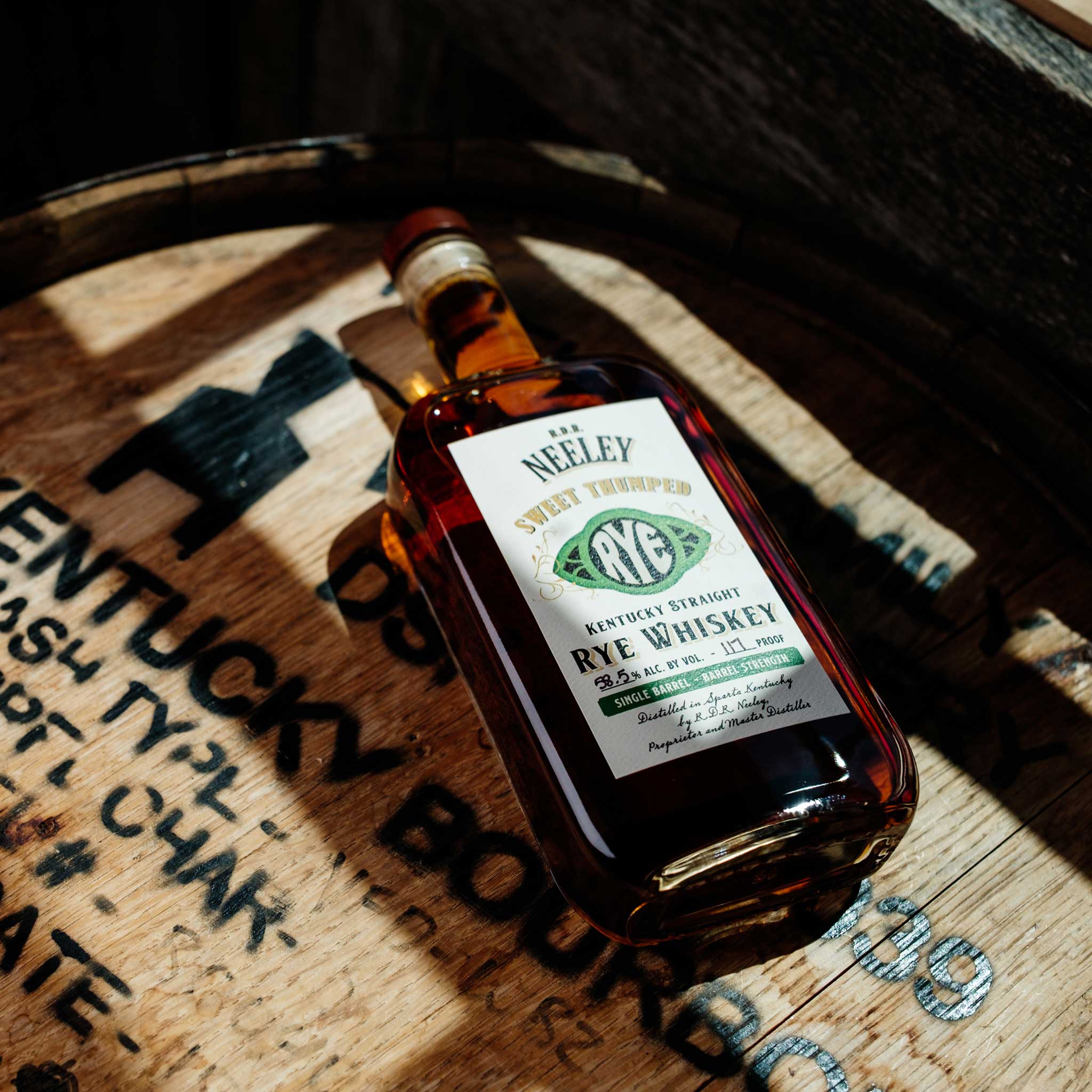 Bottle of Neeley Family Distillery Rye Whiskey on a wooden barrel